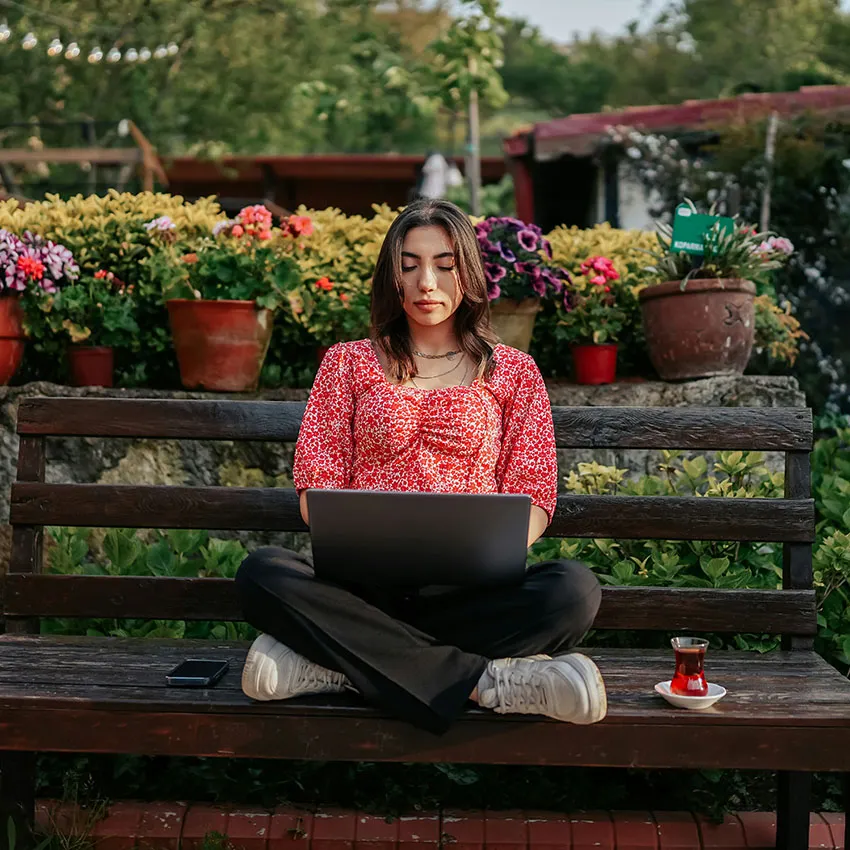 Woman working on laptop outdoors